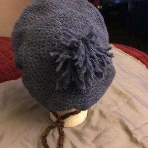 Hand crafted knit hat w/ self tie sizing.